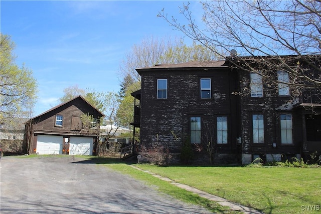 view of side of home with a lawn and a detached garage