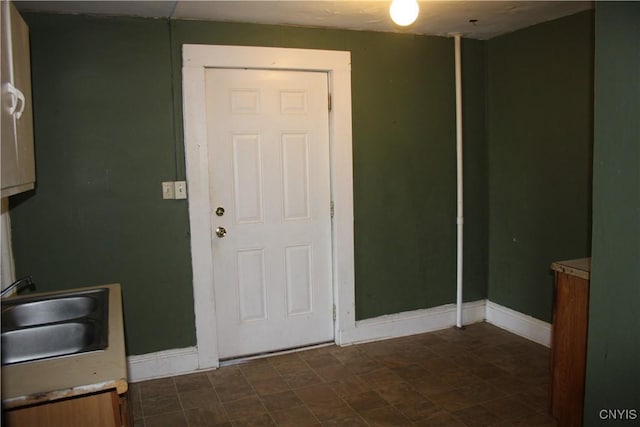 interior space featuring baseboards and a sink