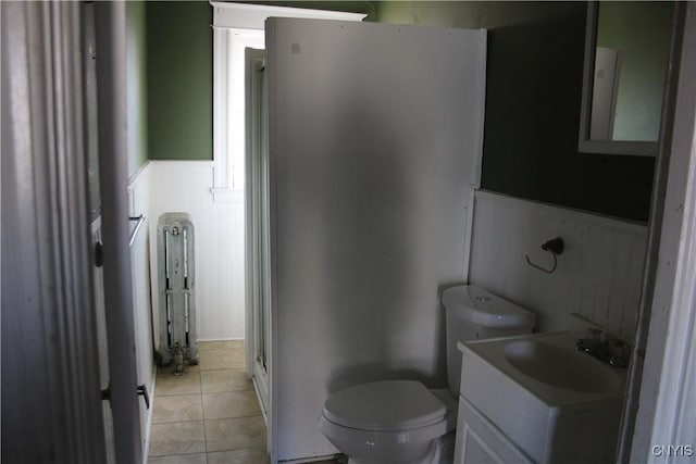 bathroom featuring tile patterned flooring, vanity, a shower, toilet, and a wainscoted wall