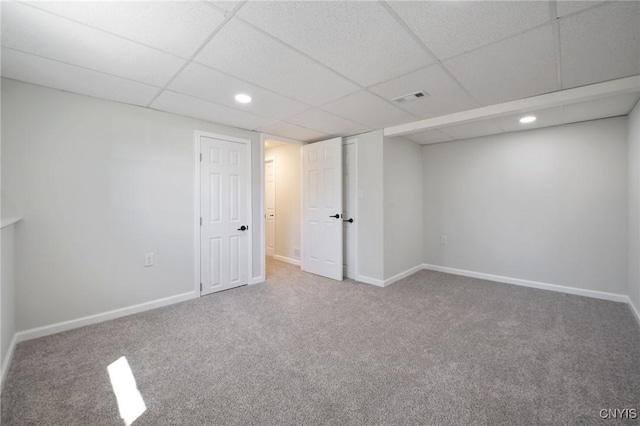 finished basement featuring visible vents, carpet flooring, baseboards, and a drop ceiling