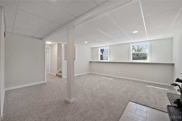 below grade area with carpet floors, a paneled ceiling, recessed lighting, baseboards, and stairway