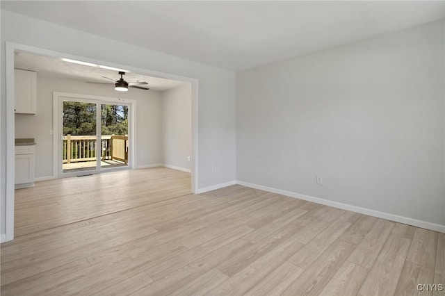 unfurnished room with ceiling fan, baseboards, and light wood finished floors