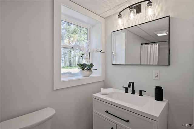 bathroom with vanity, toilet, and curtained shower