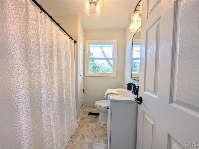 bathroom featuring vanity, marble finish floor, baseboards, and toilet