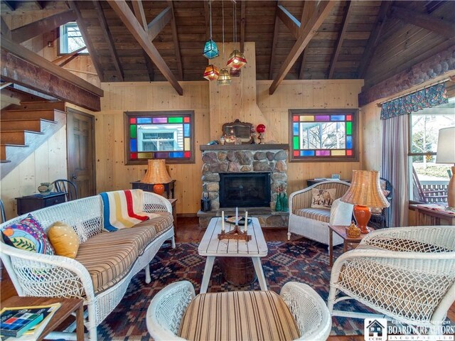 living area featuring wooden walls, beamed ceiling, and wooden ceiling