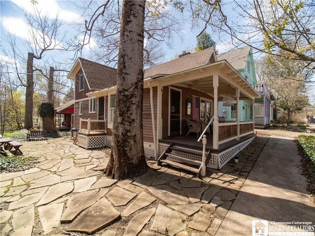 view of front of house with roof with shingles and covered porch