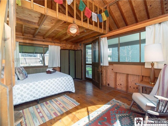 bedroom featuring wood-type flooring and wood walls
