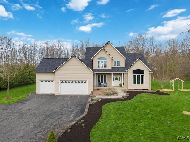 traditional-style home with a porch, aphalt driveway, a front lawn, and an attached garage