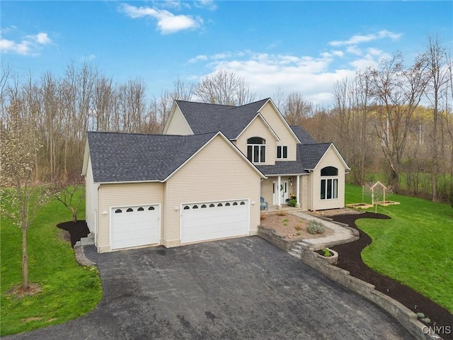 traditional-style house with roof with shingles, an attached garage, a front lawn, and aphalt driveway