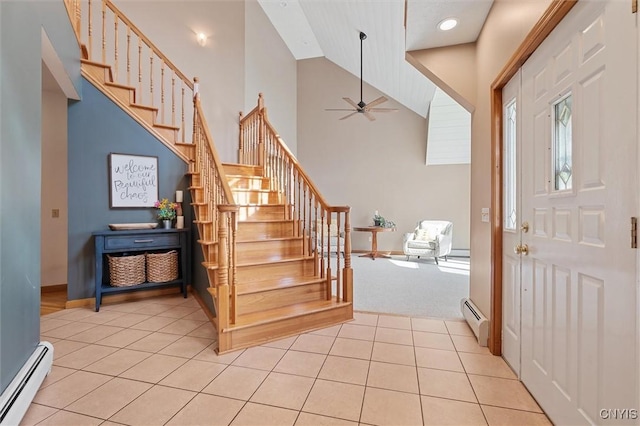 entryway featuring stairs, ceiling fan, light tile patterned flooring, and baseboard heating