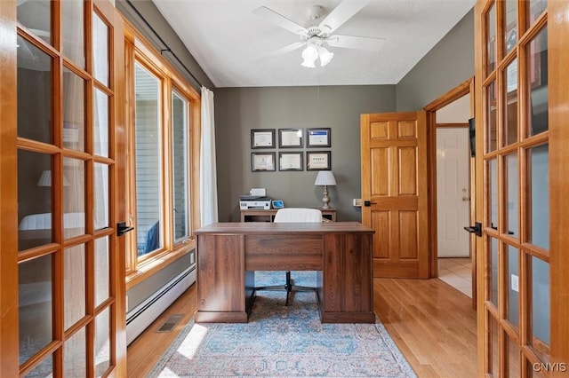 office area with french doors, a ceiling fan, light wood finished floors, and baseboard heating