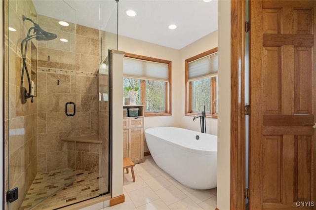 bathroom with tile patterned flooring, recessed lighting, a freestanding bath, and a stall shower