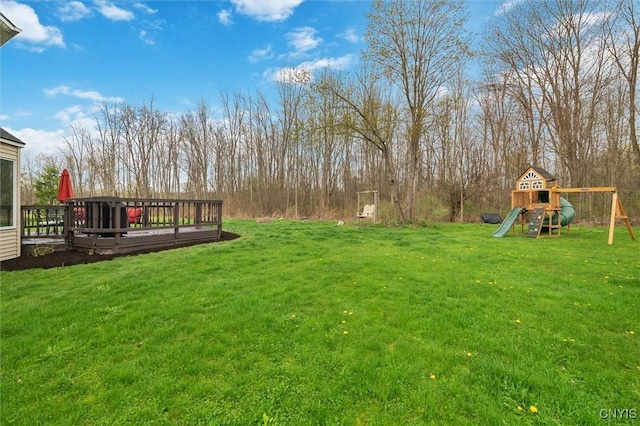view of yard with a playground and a deck