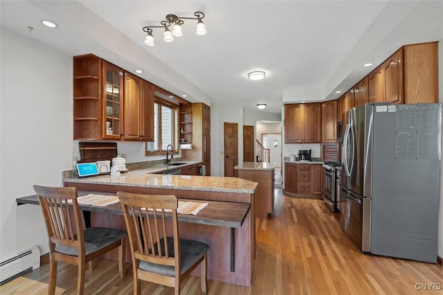 kitchen with open shelves, a peninsula, baseboard heating, light wood finished floors, and stainless steel appliances