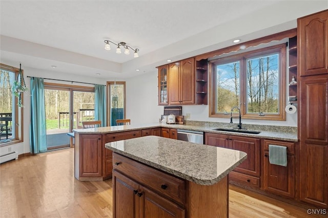 kitchen featuring a kitchen island, open shelves, a sink, light wood finished floors, and a peninsula