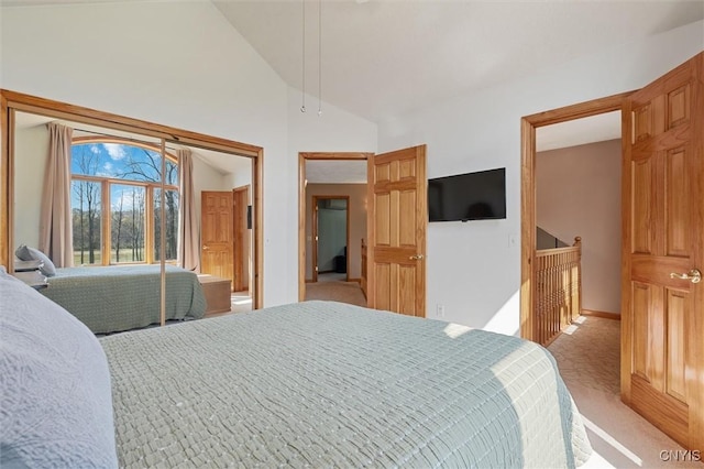 bedroom with light colored carpet, baseboards, and vaulted ceiling