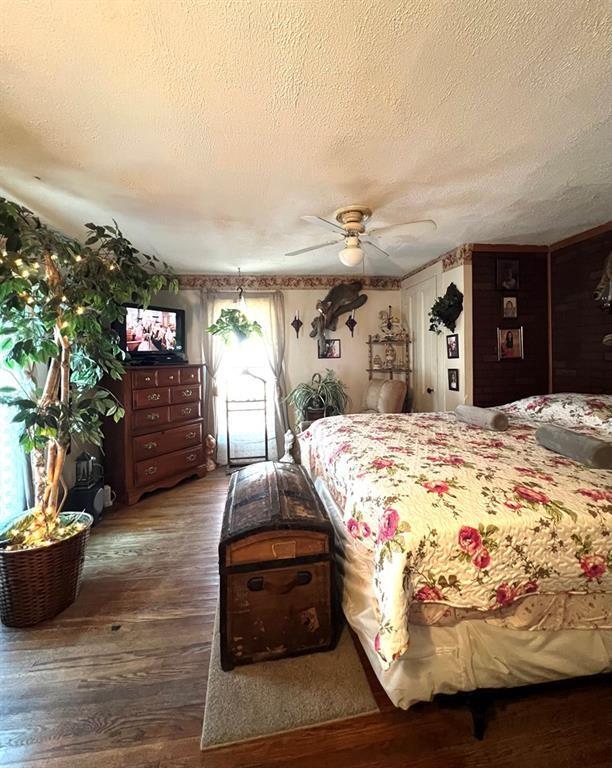 bedroom featuring a textured ceiling, ceiling fan, and hardwood / wood-style flooring