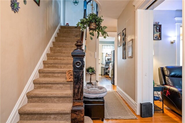 stairway with baseboards and wood finished floors
