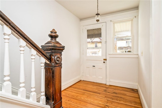doorway to outside featuring stairway, baseboards, and light wood-style flooring