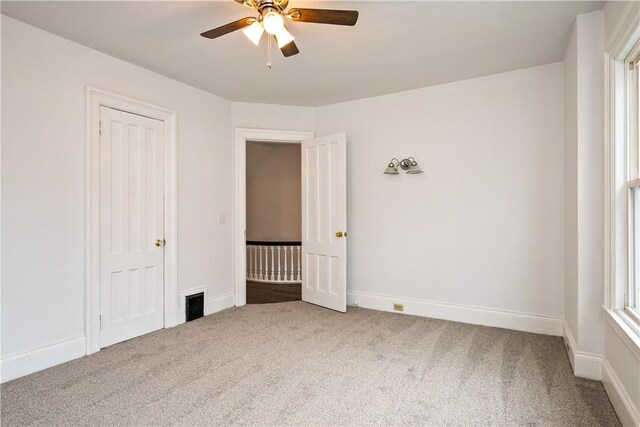 unfurnished bedroom with carpet floors, baseboards, and visible vents