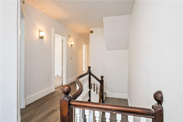 staircase featuring baseboards and wood finished floors