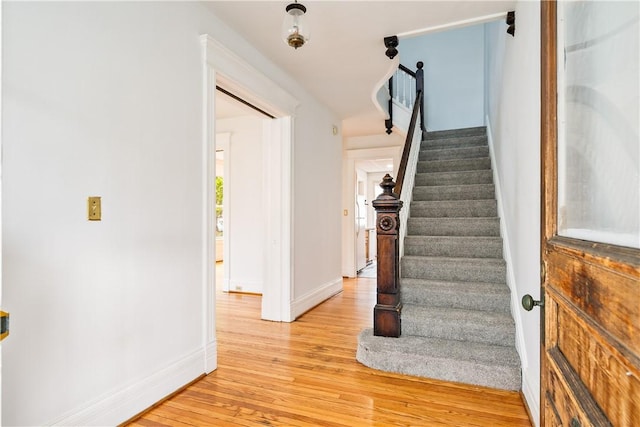 staircase with baseboards and wood finished floors