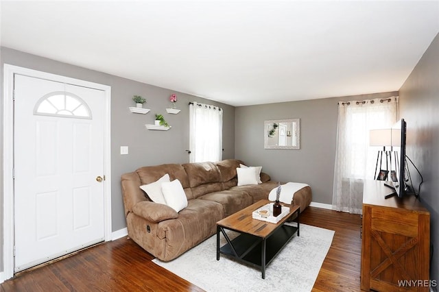 living room with dark wood-style flooring, baseboards, and a healthy amount of sunlight