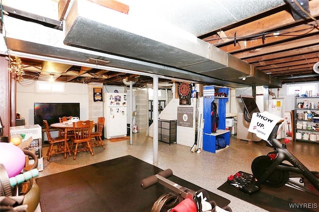 basement featuring water heater and freestanding refrigerator