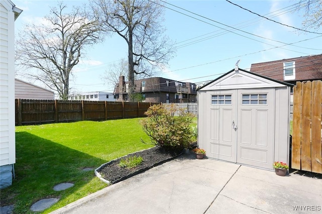 view of yard with a storage shed, an outdoor structure, a fenced backyard, and a patio area