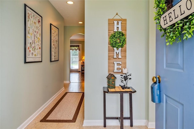 hallway with arched walkways, baseboards, and recessed lighting