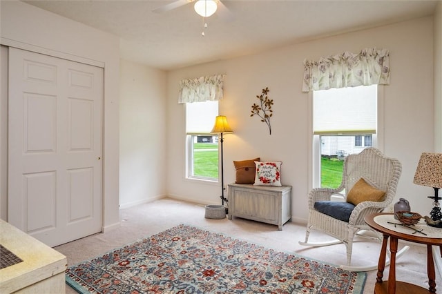 sitting room featuring baseboards, a ceiling fan, and carpet flooring
