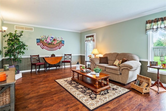 living room with visible vents, crown molding, wood finished floors, and a wainscoted wall