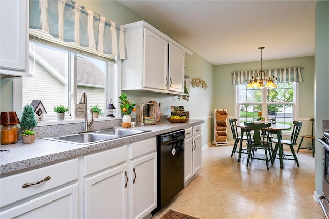 kitchen with decorative light fixtures, a sink, light countertops, white cabinets, and black dishwasher