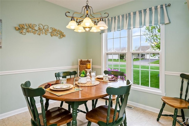 dining space with baseboards and a chandelier