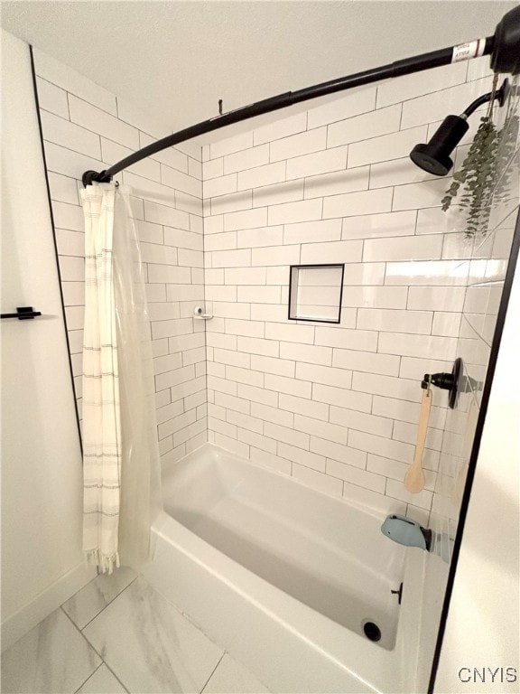 full bathroom featuring baseboards, marble finish floor, and shower / tub combo