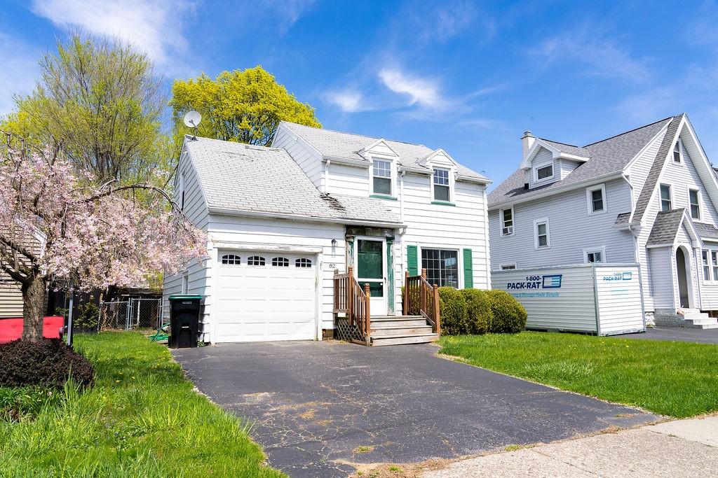 view of front of house featuring a garage, fence, driveway, and a front yard