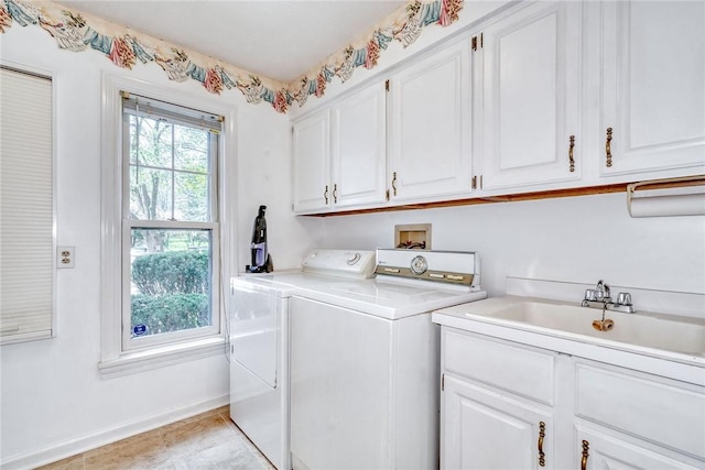 washroom featuring a sink, baseboards, cabinet space, and independent washer and dryer