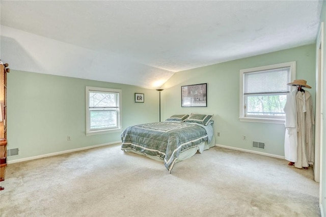 bedroom with visible vents, carpet, baseboards, and vaulted ceiling