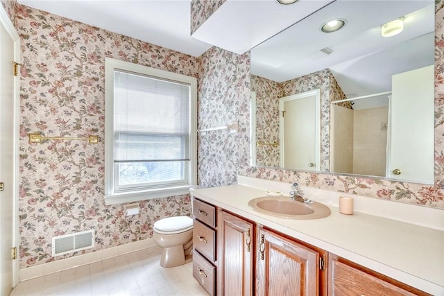 bathroom with visible vents, walk in shower, baseboards, vanity, and toilet