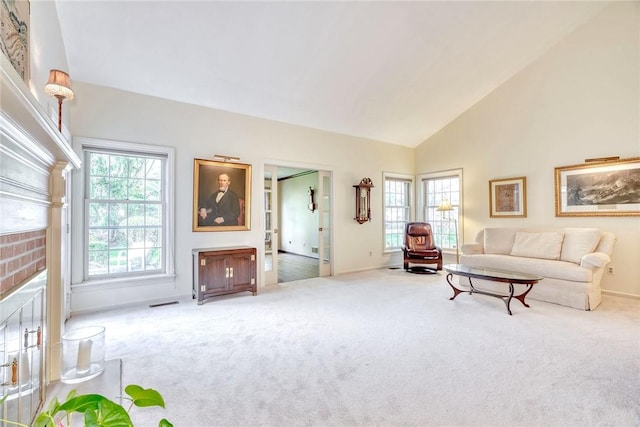 living area featuring carpet floors, baseboards, visible vents, and high vaulted ceiling