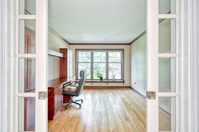 office area featuring crown molding, a textured ceiling, baseboards, and light wood-style flooring
