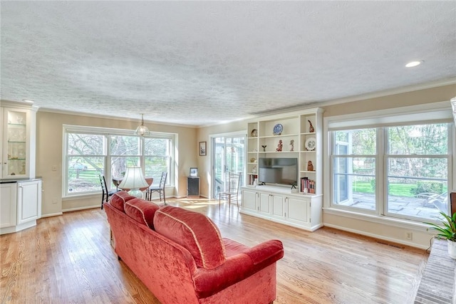 living area featuring visible vents, light wood-style flooring, and a wealth of natural light