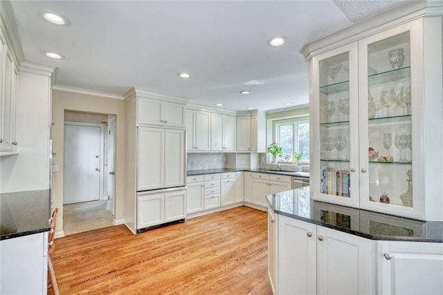 kitchen featuring white cabinets, ornamental molding, and light wood finished floors