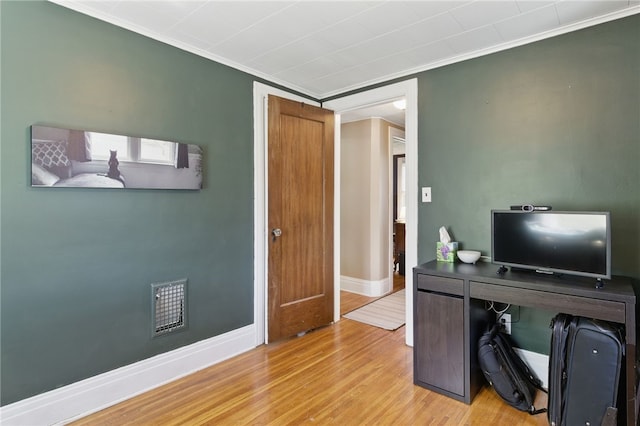 office area with crown molding, baseboards, and wood finished floors