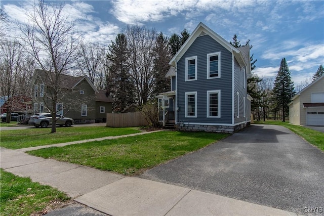 traditional-style home featuring a front yard and aphalt driveway
