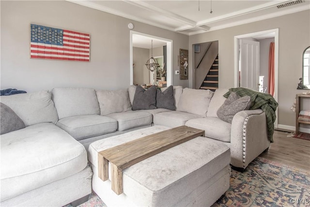 living room featuring visible vents, wood finished floors, and stairway
