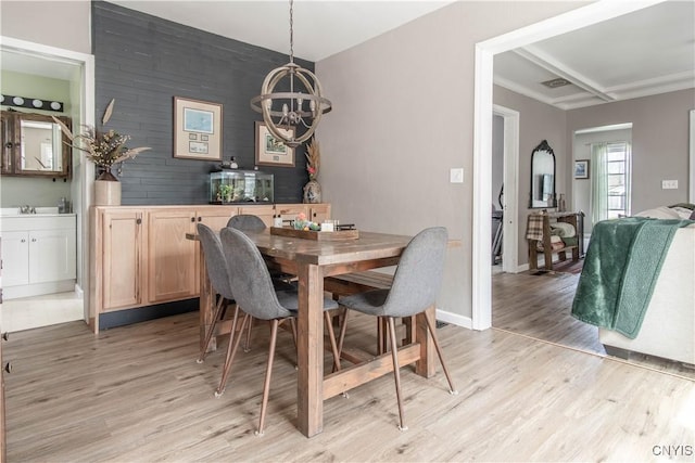 dining area with light wood-style floors, baseboards, a chandelier, and visible vents