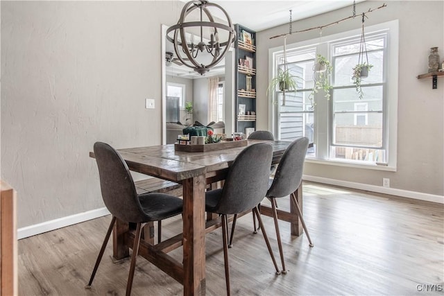 dining room with baseboards, wood finished floors, and a chandelier