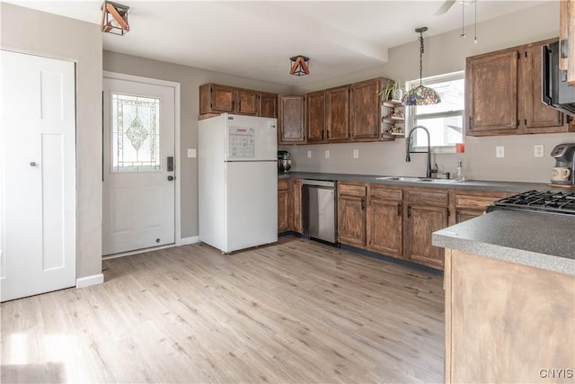 kitchen with freestanding refrigerator, light wood-style floors, a sink, dishwasher, and decorative light fixtures