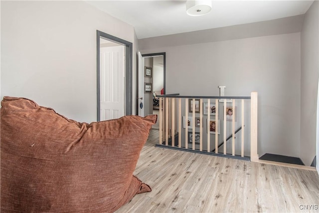 hall featuring an upstairs landing and wood finished floors
